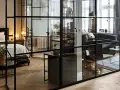 Une verrière noire sépare élégamment une chambre d'un salon, permettant de séparer une pièce en deux sans travaux.