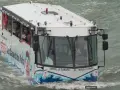 Le bus amphibie "Les Canards de Paris" navigue sur l'eau, transportant des touristes masqués pour une visite unique de la ville.