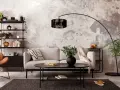 Salon industriel cocooning : canapé gris, fauteuil orange, étagère noire, table basse noire, tapis sombre, mur texturé.
