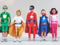 Cinq enfants déguisés en super-héros, avec des capes et des masques colorés.