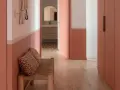 Banc en rotin avec coussins léopard, murs bicolores corail et blanc, portes roses. Une belle idée déco couloir moderne.