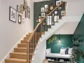 Escalier moderne avec mur de cadres et papier peint graphique. Une banquette confortable sous l'escalier, une belle idee couleur cage escalier.