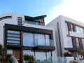 Maison moderne aux lignes épurées, avec une **couleur de façade maison tendance** mêlant blanc, noir et touches de bois.