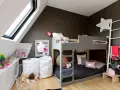 Lit superposé gris pour séparer une chambre pour 2 ados. Jouets, sacs blancs et déco murale étoilée.
