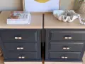 Deux tables de chevet relookées : tiroirs bleu nuit, plateaux clairs, poignées en rotin. Un projet réussi pour relooker un meuble en bois foncé.