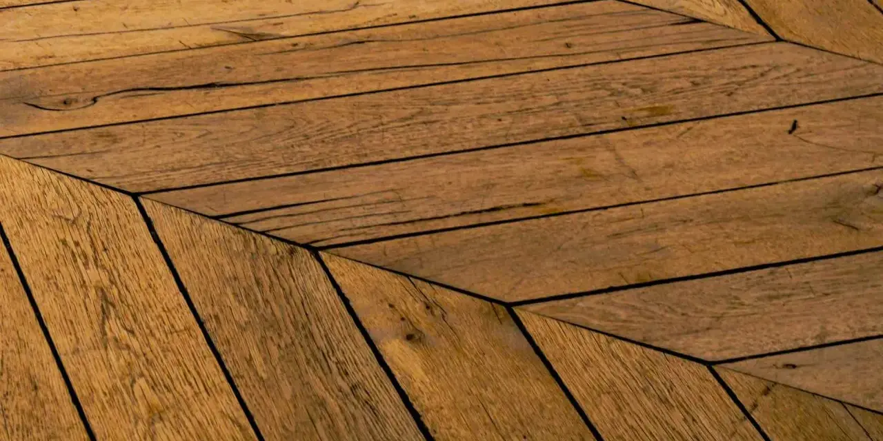 Parquet en bois vieilli, pose en chevrons. Un style intemporel pour savoir quel parquet choisir.