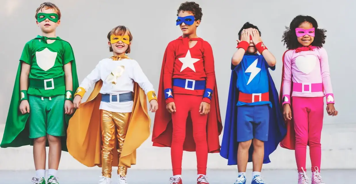 Cinq enfants déguisés en super-héros, avec des capes et des masques colorés.