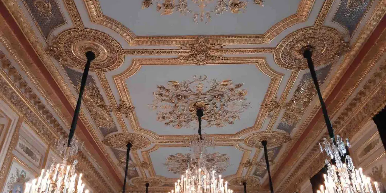 Plafond orné et lustres en cristal dans le salon du **Hôtel de la Marine**.