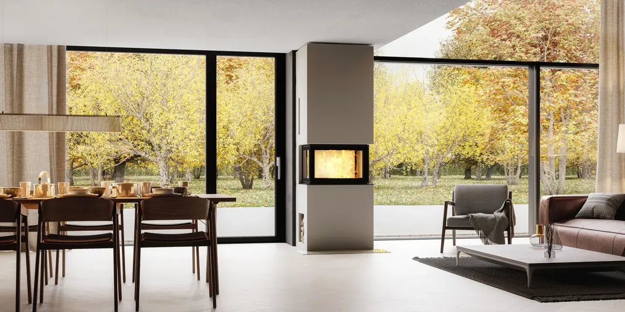 Un salon moderne avec une cheminée design, une table à manger et de grandes baies vitrées offrant une vue sur un jardin d'automne. Idéal pour moderniser une cheminée.