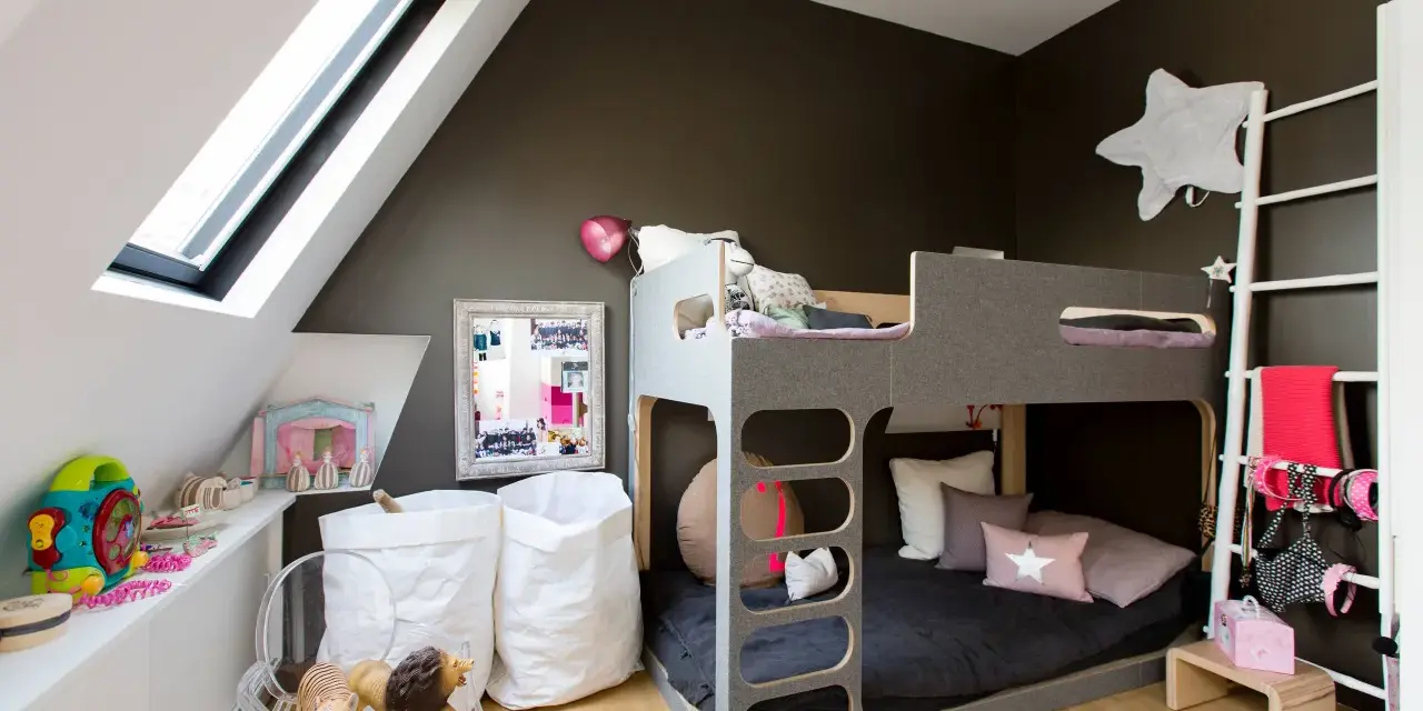 Lit superposé gris pour séparer une chambre pour 2 ados. Jouets, sacs blancs et déco murale étoilée.