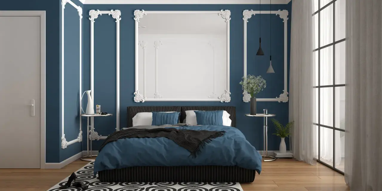 Chambre élégante avec murs bleu nuit et moulures blanches. Le lit est paré de linge de lit bleu roi, créant 2 couleurs qui vont bien ensemble pour une chambre.