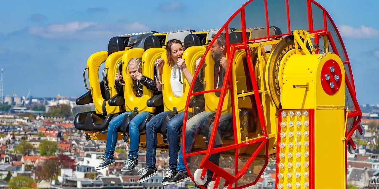 Famille en plein fou rire sur une attraction à sensations fortes, un avant-goût du meilleur parc d'attractions de France.