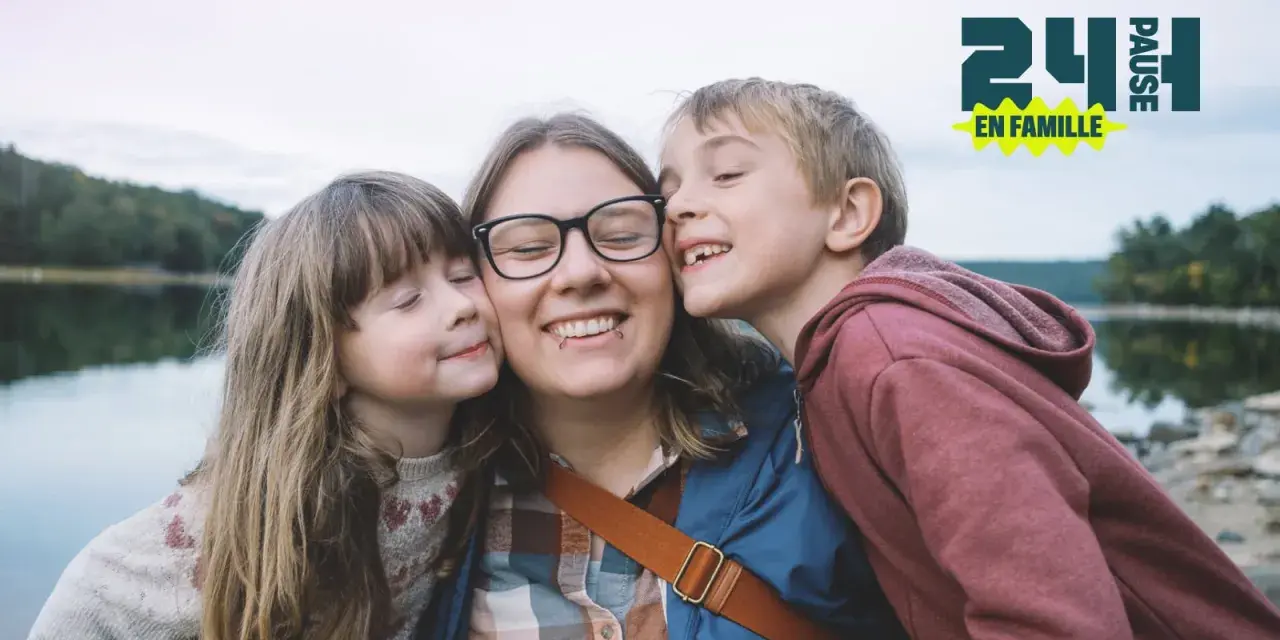 Une mère et ses deux enfants s'embrassent près d'un lac. Une belle idée pour savoir que faire le 1er mai en famille.