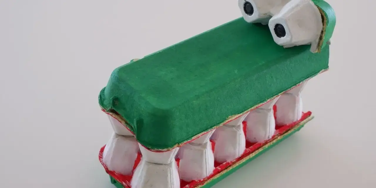 Un crocodile rigolo, fruit d'un bricolage avec des boîtes d'œufs. Ses dents blanches et sa gueule rouge font un effet saisissant.