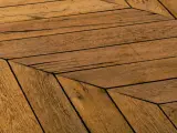 Parquet en bois vieilli, pose en chevrons. Un style intemporel pour savoir quel parquet choisir.