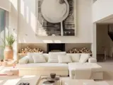 Un **salon beige et blanc** lumineux avec un grand canapé, une cheminée ornée de bois et une œuvre d'art abstraite.