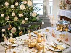Déco table de Noël pas cher à faire soi-même : sapin décoré, citrouilles dorées, guirlandes lumineuses et vaisselle festive créent une ambiance chaleureuse.