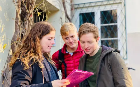 Trois amis consultent une carte rose, prêts pour leur escape game Montmartre.