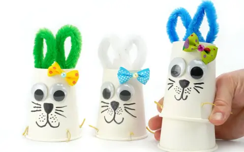 Trois adorables lapins de Pâques bricolage faits avec des gobelets en papier, des pompons et des yeux mobiles. Parfait pour une activité de Pâques !