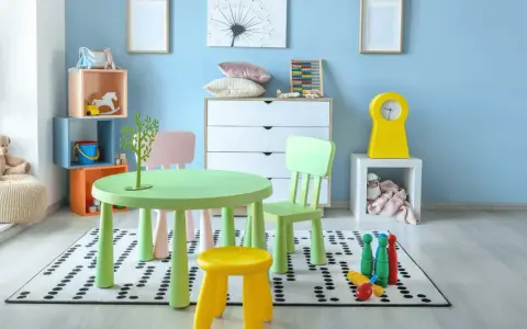 Salle de jeux lumineuse avec table verte, chaises colorées, jouets et peluche sur fond bleu clair.