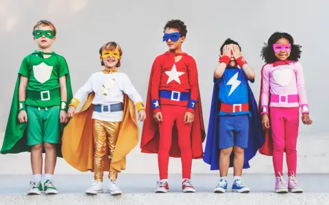 Cinq enfants déguisés en super-héros, avec des capes et des masques colorés.