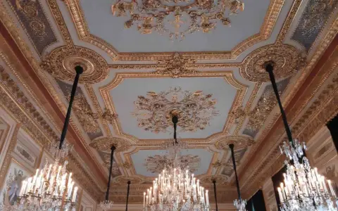 Plafond orné et lustres en cristal dans le salon du **Hôtel de la Marine**.