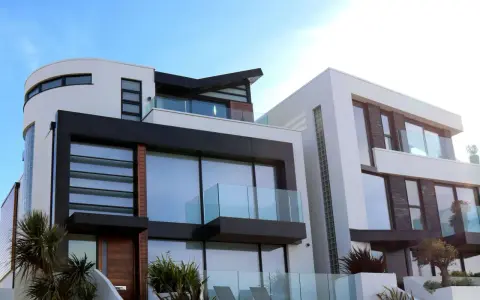 Maison moderne aux lignes épurées, avec une **couleur de façade maison tendance** mêlant blanc, noir et touches de bois.
