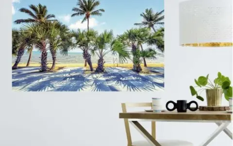 Une **déco murale originale** de palmiers sur une plage ensoleillée, projetant de longues ombres sur le sol.