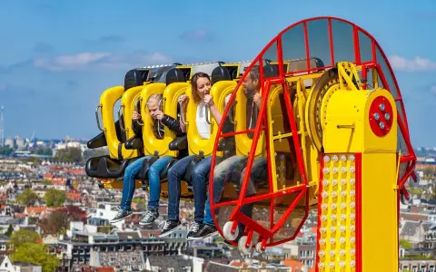 Famille en plein fou rire sur une attraction à sensations fortes, un avant-goût du meilleur parc d'attractions de France.