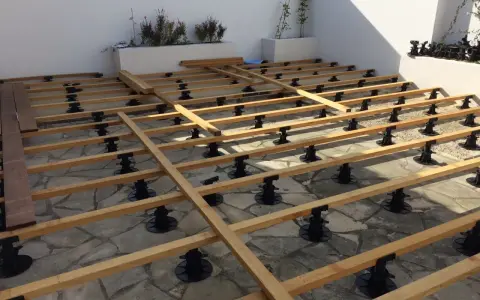 Structure en bois pour un aménagement terrasse en bois, sur des plots réglables. Les lames de bois sont prêtes à être posées.