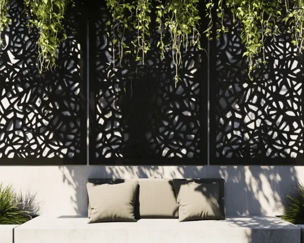 Panneaux décoratifs ajourés, parfaits pour une idée déco mur extérieur jardin. Un banc confortable avec coussins et verdure luxuriante complètent ce coin détente.