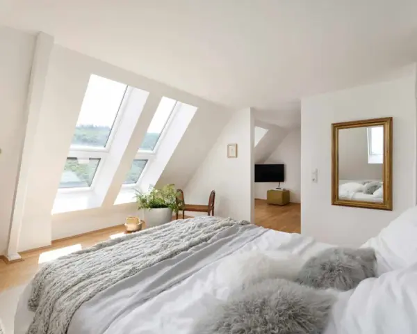 Douillette chambre mansardée avec lits douillets, fenêtres de toit lumineuses et vue sur la verdure. Un coin paisible pour se détendre.