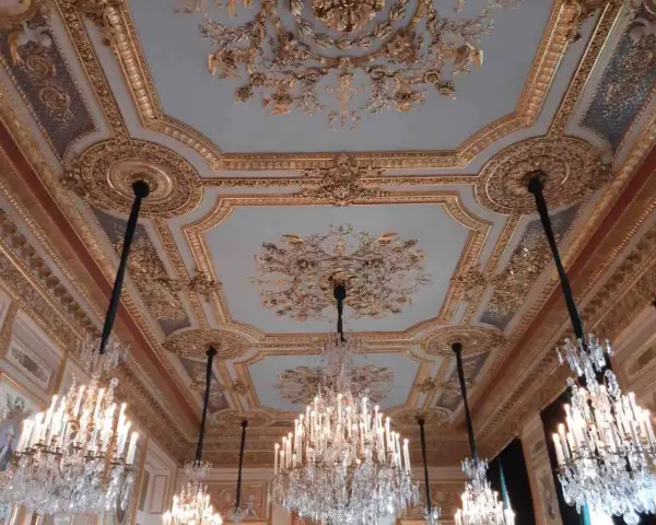 Plafond orné et lustres en cristal dans le salon du **Hôtel de la Marine**.