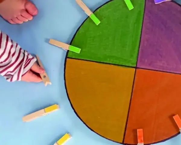 Main colorée avec des pinces à linge pour des activités enfant 2 ans.