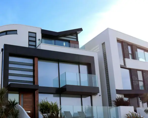 Maison moderne aux lignes épurées, avec une **couleur de façade maison tendance** mêlant blanc, noir et touches de bois.