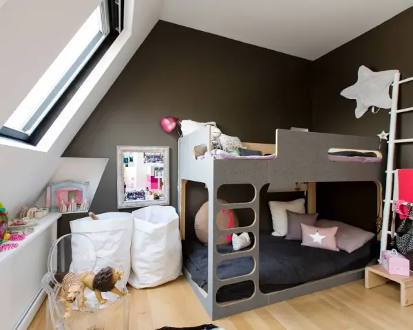 Lit superposé gris pour séparer une chambre pour 2 ados. Jouets, sacs blancs et déco murale étoilée.