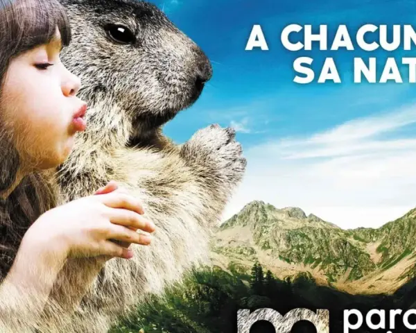 Avis sur parc animalier des Pyrénées : une fillette et une marmotte se regardent, avec des montagnes en arrière-plan.