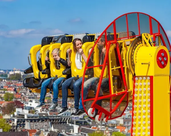 Famille en plein fou rire sur une attraction à sensations fortes, un avant-goût du meilleur parc d'attractions de France.