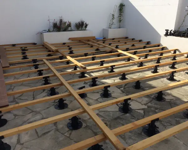 Structure en bois pour un aménagement terrasse en bois, sur des plots réglables. Les lames de bois sont prêtes à être posées.