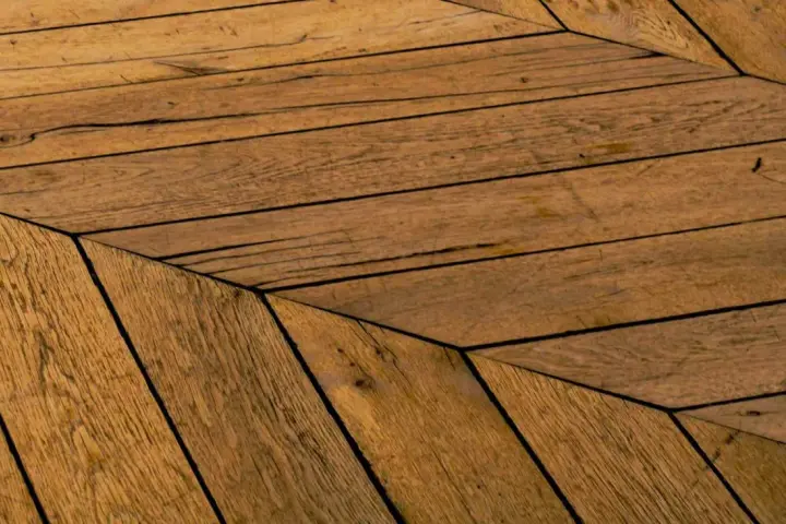 Parquet en bois vieilli, pose en chevrons. Un style intemporel pour savoir quel parquet choisir.
