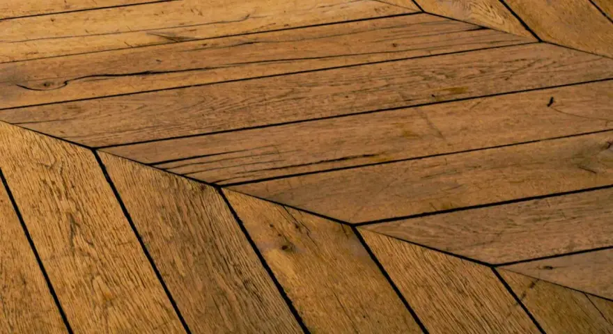 Parquet en bois vieilli, pose en chevrons. Un style intemporel pour savoir quel parquet choisir.