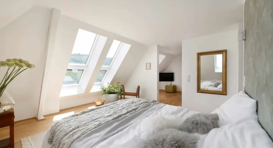 Douillette chambre mansardée avec lits douillets, fenêtres de toit lumineuses et vue sur la verdure. Un coin paisible pour se détendre.