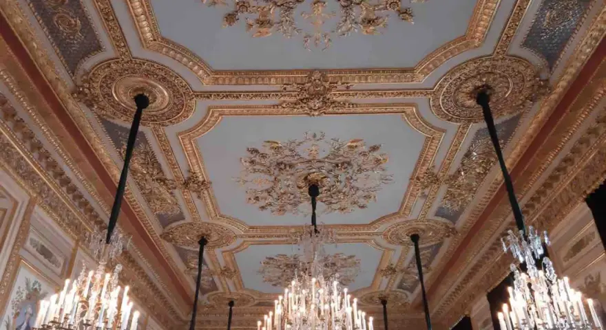 Plafond orné et lustres en cristal dans le salon du **Hôtel de la Marine**.