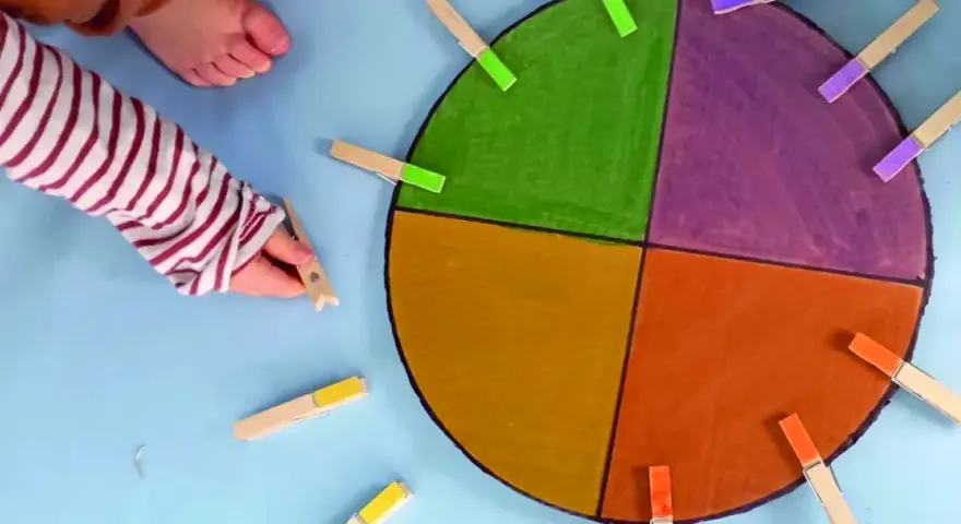 Main colorée avec des pinces à linge pour des activités enfant 2 ans.