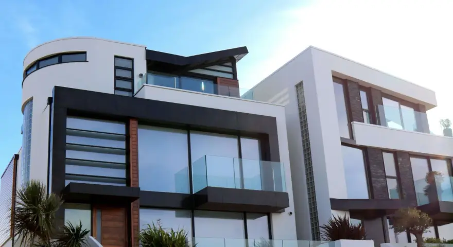 Maison moderne aux lignes épurées, avec une **couleur de façade maison tendance** mêlant blanc, noir et touches de bois.