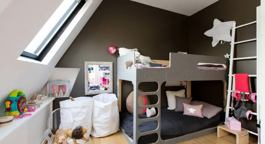 Lit superposé gris pour séparer une chambre pour 2 ados. Jouets, sacs blancs et déco murale étoilée.