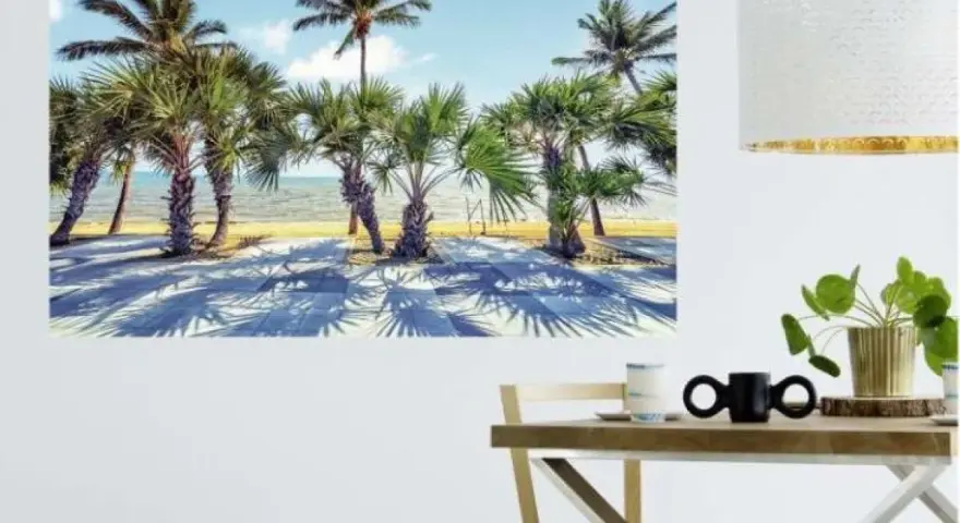 Une **déco murale originale** de palmiers sur une plage ensoleillée, projetant de longues ombres sur le sol.
