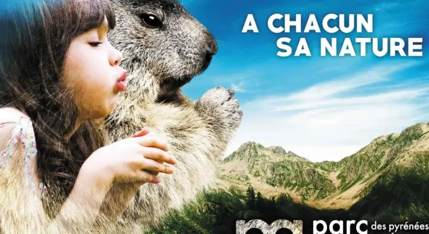 Avis sur parc animalier des Pyrénées : une fillette et une marmotte se regardent, avec des montagnes en arrière-plan.