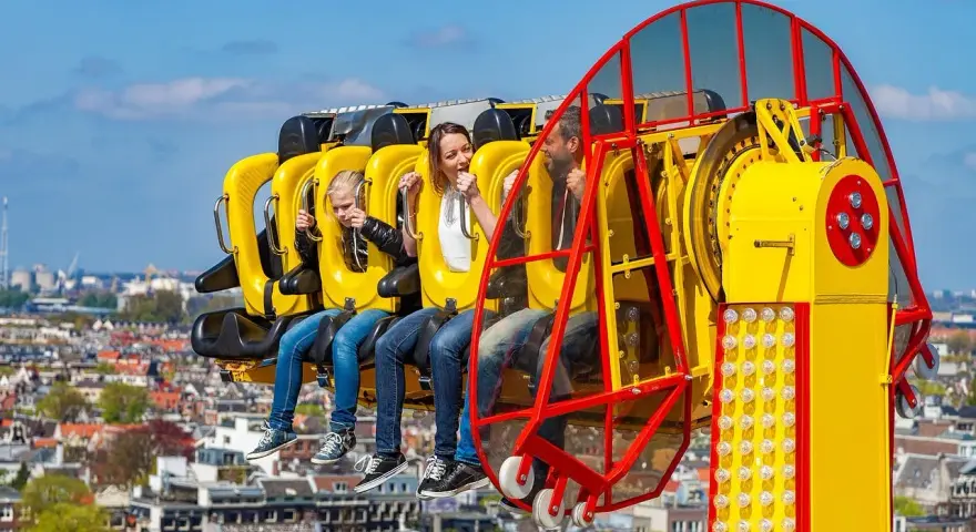Famille en plein fou rire sur une attraction à sensations fortes, un avant-goût du meilleur parc d'attractions de France.