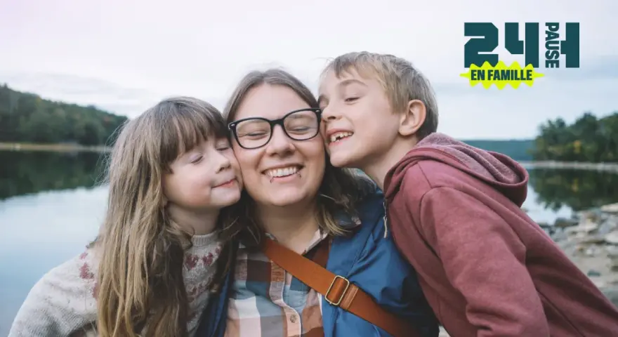 Une mère et ses deux enfants s'embrassent près d'un lac. Une belle idée pour savoir que faire le 1er mai en famille.